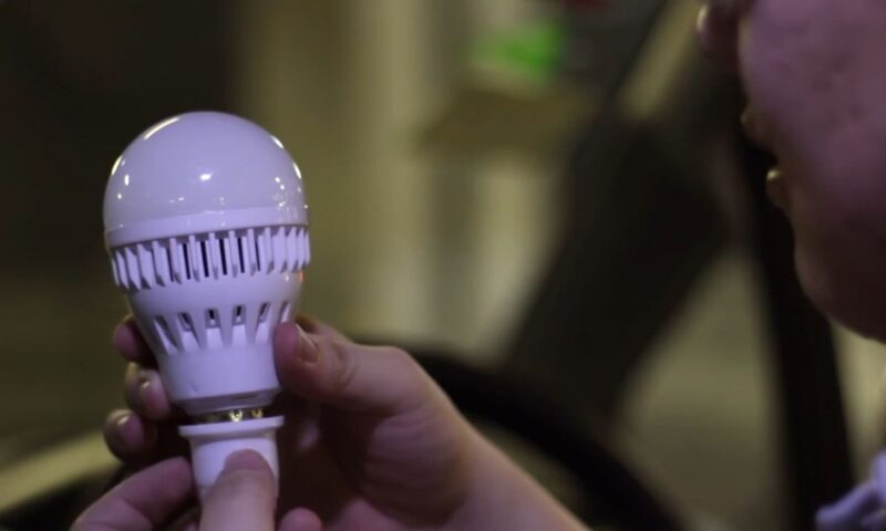 momak drži sijalicu u ruci