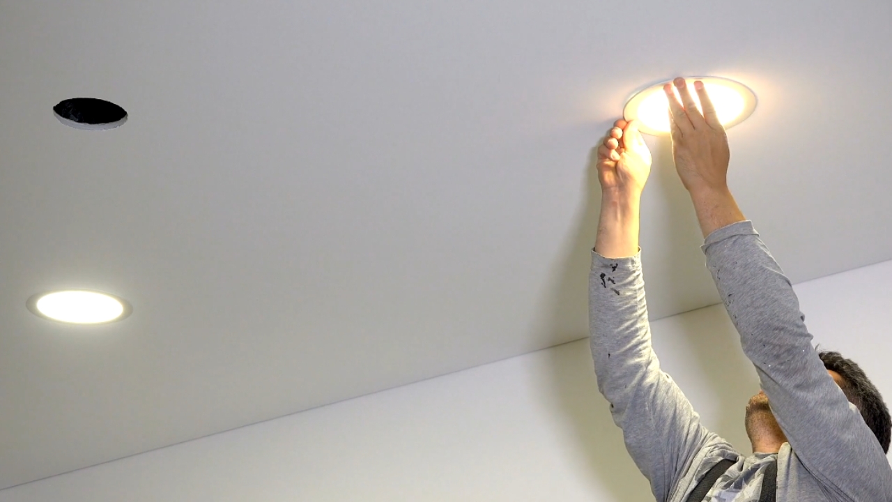 Majstor ugrađuje okrugli LED panel u plafon